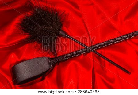 Bondage, Kinky Adult Sex Games, Kink And Bdsm Lifestyle Concept With A Whip, Feather Stick On Red Si