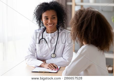 Friendly Black Therapist Listening Adolescent Girl During Reception