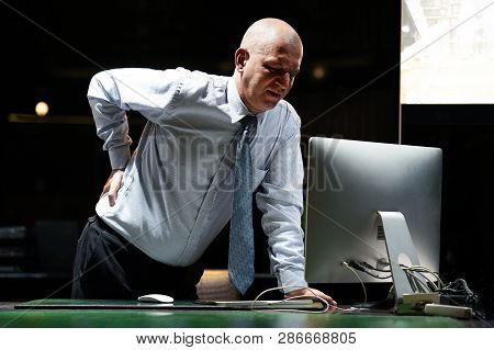 Close-up View Of Elderly Man-reception Worker Hotel Manager With Pain In Kidneys. Man With Back Ache