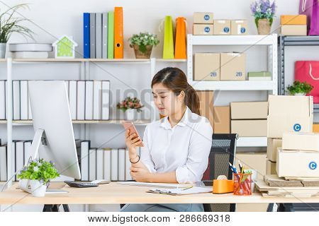 Young Beautiful, Attractive Asian Businesswoman With Pony Tail, White Shirt, Sitting In Front Of Com