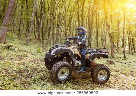 The Boy Is Traveling On An Atv.