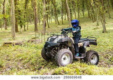 The Boy Is Traveling On An Atv.