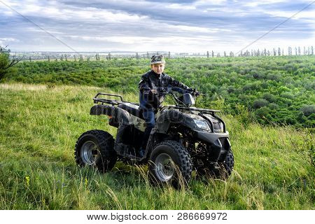 The Boy Is Traveling On An Atv.