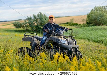 The Boy Is Traveling On An Atv.