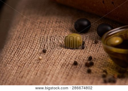 Fresh Bread Baguette With Olive Oil, Olives. Cheese And Rosemary On Wooden Background. Teasty Breakf