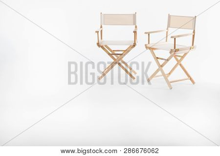 Two Director Chair Made Of Wood And Fabric Well Comfortable Sitting On A White Backdrop, Copy Space