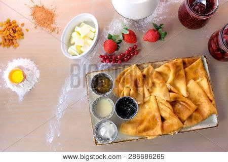 Russian Traditional Pancakes, Blini Served With Jams, Sour Cream, And Strawberry On The Plate. Close
