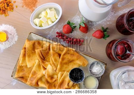 Russian Traditional Pancakes, Blini Served With Jams, Sour Cream, And Strawberry On The Plate. Close