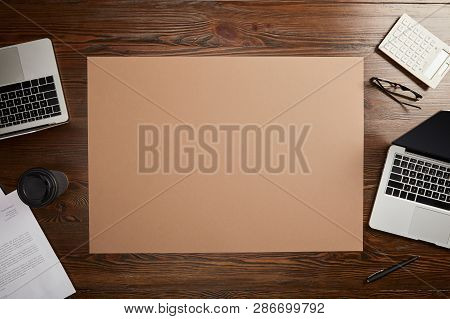 Top View Of Documet, Paper Cup, Laptops, Pen, Calculator, Pen, Glasses And Blank Placard