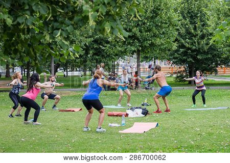 Moscow, Museon Park, July 14, 2018: Group Of Man And Women In Sportswear Doing Physical Exercises Wi
