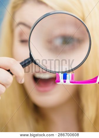 Beautiful Perfectionist Young Woman Checking Her Tooth Brush Through Manifying Loupe Glass. Hygiene,