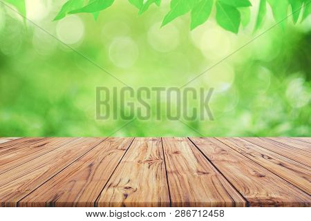 Empty Wooden Deck Table Top On Green Blurred Abstract Background From Foliage Background. Ready Used