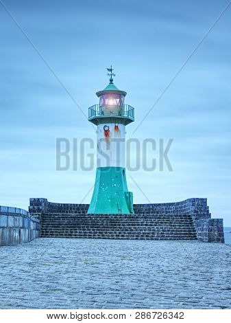 Shinning Lighthouse At The End Of Stony Pier. Cloudy Eveningafter Rainy Day, Sassnitz, Germany