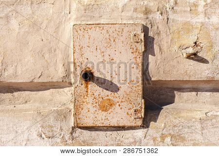 Rusty Metal Door Of The Electric Box. Old Abandoned Electrical Junction Box On The Wall Of An Old Ho