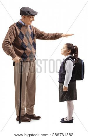 Full length shot of a grandfather gesturing with hand and showing the height of his granddaughter isolated on white background