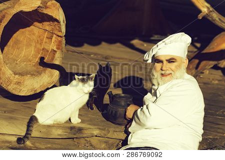 Bearded Man Cook Chef In Uniform And Hat With Long Beard On Smiling Face Holding Iron Old Tea Kettle