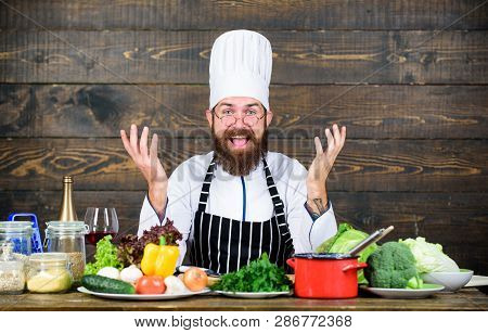 Happy Bearded Man Cooking In Kitchen. Dieting With Organic Food. Fresh Vegetables. Vitamin. Man Use 