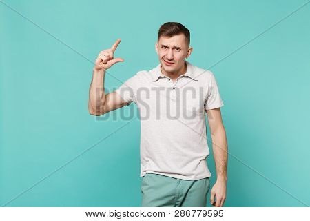 Bewildered Young Man In Casual Clothes Gesturing Demonstrating Size With Workspace Isolated On Blue 