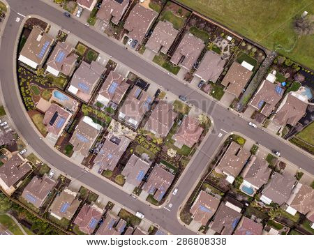 Aerial straight down view of streets and houses, many with solar panels in Folsom, California.