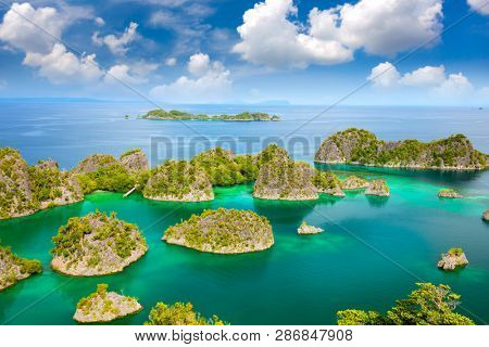 Aerial view of paradise islands in turquoise sea with reef islands coastline, beautiful lagoons. Indonesia