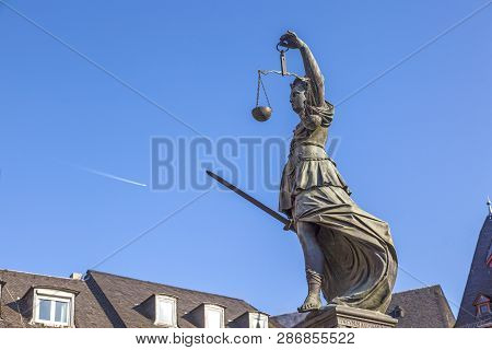 Lady Justice Standing At The Fountain Under Blue Sky In Frankfurt As A Symbol Of Justice