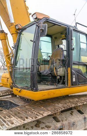 The Cab And Dirty Grousers Of A Yellow Excavator