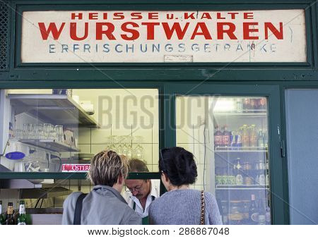 Vienna, Austria - May, 22: A Couple Of Friend Waiting A Hot Dog In Typical Viennese Fast Food Snack 