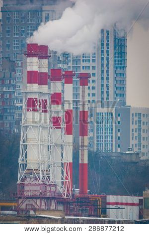 Air Pollution From Industrial Plants. Smoking Industrial Pipes. Red With White Pipe.