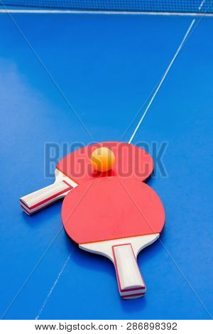 Pingpong Rackets And Ball And Net On A Blue Pingpong Table