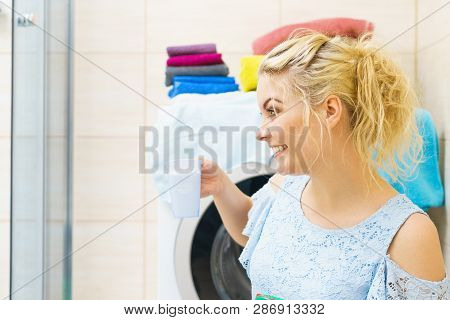 Woman Showing Washing Powder Detergent And Measuring Cup. Household Duties, Clothes Laundry Obejcts 