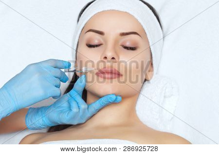 The Doctor Cosmetologist Makes Lip Augmentation Procedure Of A Beautiful Woman In A Beauty Salon.cos
