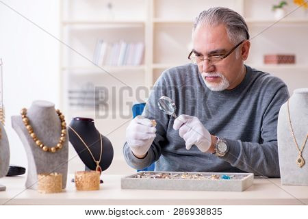 White bearded old jeweler at workshop 