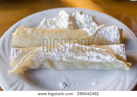 A White Plate With Food And A A White Cup Are On The Wooden Table. Ready To Eat Concept. Tasty Food 