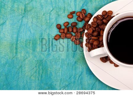Café na xícara com café em grãos e em torno do Soucer