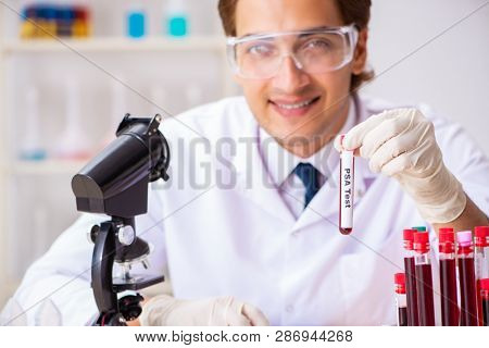 Young handsome lab assistant testing blood samples in hospital 