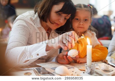 Lviv, Ukraine - March 11, 2018. Mom And Daughter Paint Easter Eggs At The Table