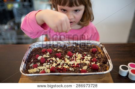 Little girl decorating Mazurek (Polish Easter cake)