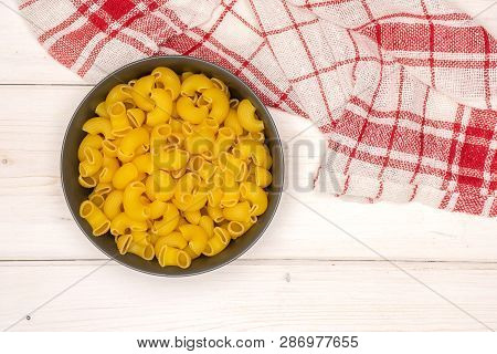 Lot Of Whole Raw Pasta Pipe Rigate Variety In A Grey Ceramic Bowl Flatlay On White Wood