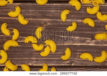 Lot Of Whole Raw Pasta Pipe Rigate Variety Flatlay On Brown Wood