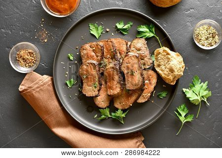 Beef Liver On Plate Over Black Stone Background. Cooked Liver(offal) From Beef Meat. Top View, Flat 