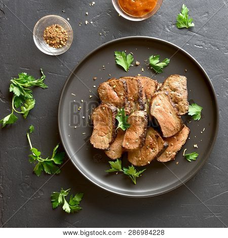 Grilled Sliced Beef Liver On Plate Over Black Stone Background. Cooked Liver(offal) From Beef Meat. 