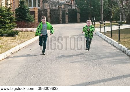 Two European Boys Run Along The Road To The Distillery.