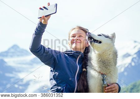 Young Pretty Girl Running Outdoor In The Spring With Mountain Dog