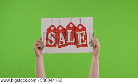 Sale Word Advertisement Inscription On Paper Sheet In Womans Hands On Green Screen. Holiday Discount