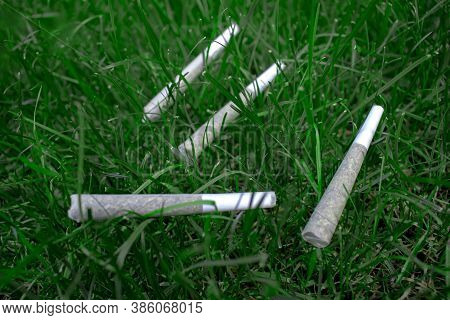 Pre-rolls Cannabis Joints Marijuana Weed On A Fresh Lawn Grass Surface.