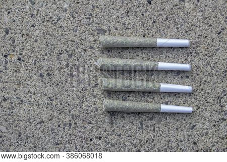 Pre-rolls Cannabis Joints And Dried Flower Marijuana On A Concrete Background