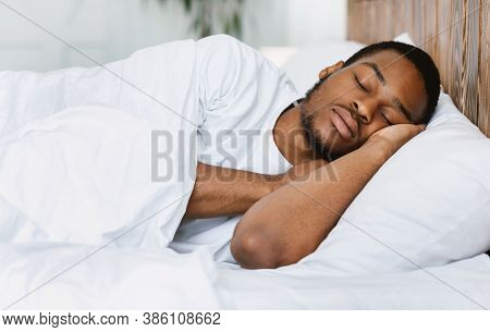 Asleep African American Guy Sleeping Resting Peacefully In His Comfortable Bed At Home, Lying With E