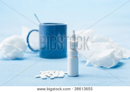 Medicamenti malattia freddo, tè e tessuti su sfondo blu