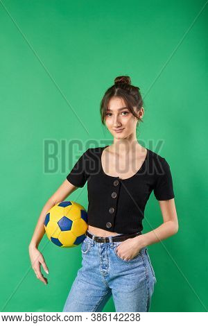 Young Caucasian Girl Holding Soccer Ball With Her Forearm. Female Football Player. Isolated On Green