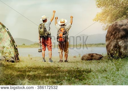 Concept Of Eco-friendly Tourism : Back View Of Two Senior Men Carrying Their Backpack And Camping Ne